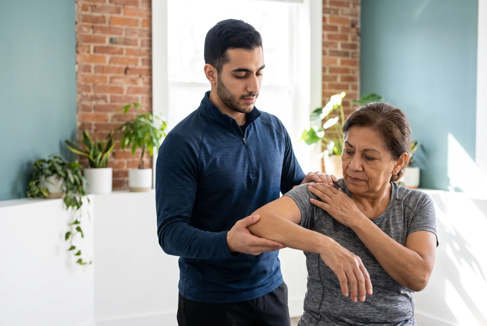 A physical therapist assessing a patient's shoulder for a rotator cuff injury
